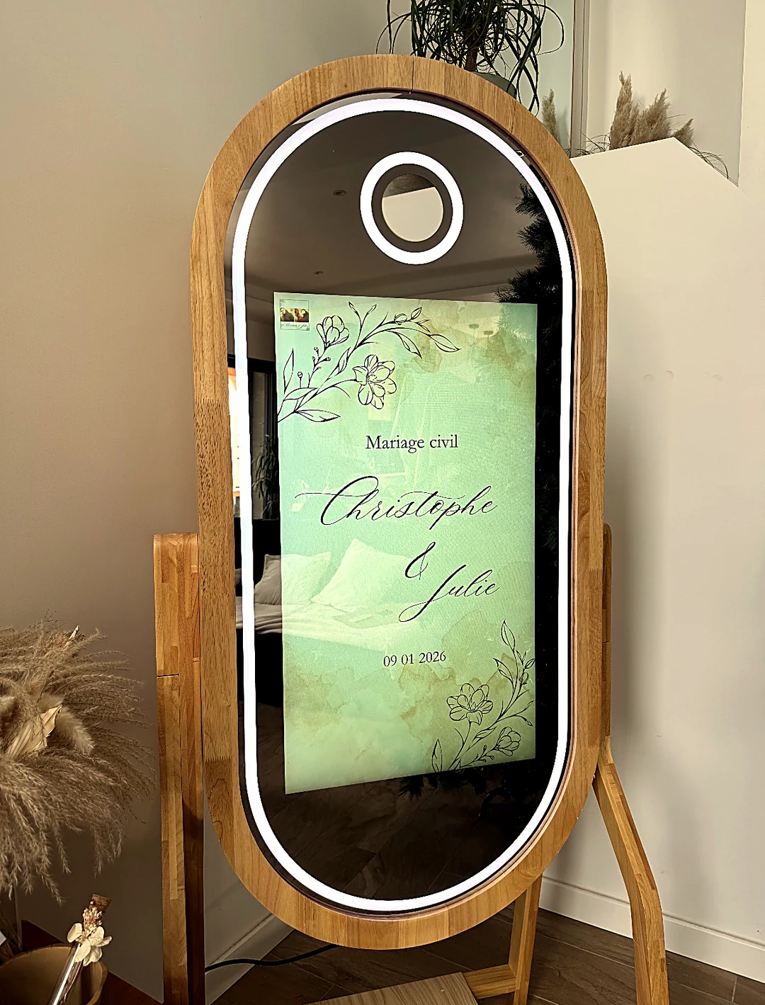 Borne photobooth miroir AEJ installée pour un mariage, écran d’accueil personnalisé et lumière chaude